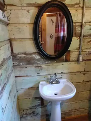 a bathroom with a sink and a mirror at The Highlander - Rustic Mountain Yurt in Genoa