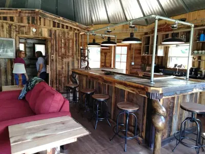 a bar with stools and a red couch in a room at The Highlander - Rustic Mountain Yurt in Genoa