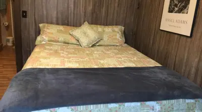 a bed in a room with a bed sidx sidx sidx at The Sandstone - A 3BR, 2BA Deluxe Log Cabin in Genoa