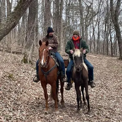 two people riding on horses in the woods at The Sandstone - A 3BR, 2BA Deluxe Log Cabin in Genoa