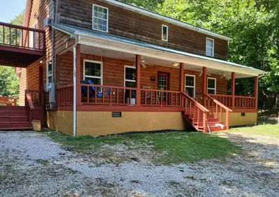 a house with a large deck on the front of it at The Bunkhouse - 3 BR, 2 BA Deluxe Cabin in Genoa