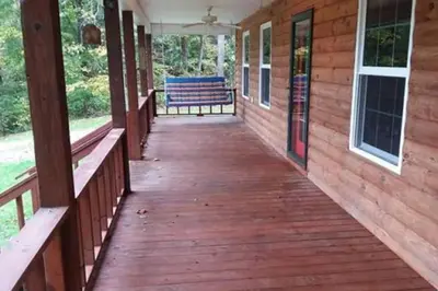 a wooden porch with a bench on a house at The Bunkhouse - 3 BR, 2 BA Deluxe Cabin in Genoa