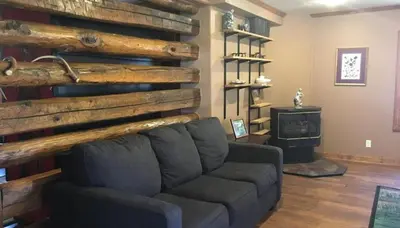 a living room with a couch and a stove at The Lodge - Chestnut Log Cabin in Genoa