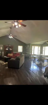 a living room with a couch and a ceiling fan at The Lodge - Chestnut Log Cabin in Genoa
