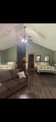 a living room with a couch and a ceiling fan at The Lodge - Chestnut Log Cabin in Genoa