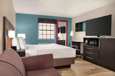 a hotel room with a bed and a flat screen tv at La Quinta Inn by Wyndham Columbus Airport Area in Columbus