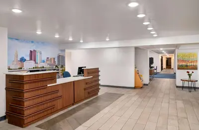 an office lobby with a desk and a guitar at La Quinta Inn by Wyndham Columbus Airport Area in Columbus