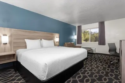 a hotel room with a large bed and a window at Baymont by Wyndham Piqua in Piqua