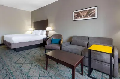 a hotel room with a bed and a bed and a couch at La Quinta by Wyndham Columbus West - Hilliard in Columbus