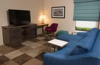 a living room with a blue couch and a television at Hampton Inn Wooster in Wooster