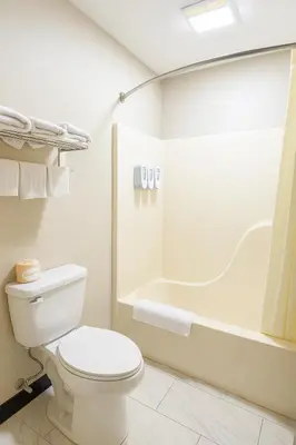 a bathroom with a toilet and a bath tub at Paragon Inn Hillsboro in Hillsboro