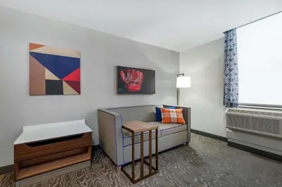a living room with a couch and a table at Hampton Inn & Suites Fort Wayne Downtown in Fort Wayne