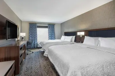 a hotel room with two beds and a flat screen tv at Hampton Inn & Suites Fort Wayne Downtown in Fort Wayne