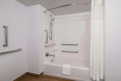 a white bathroom with a tub and a shower at Hampton Inn & Suites Fort Wayne Downtown in Fort Wayne
