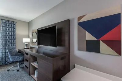 a hotel room with a desk with a tv and a chair at Hampton Inn & Suites Fort Wayne Downtown in Fort Wayne