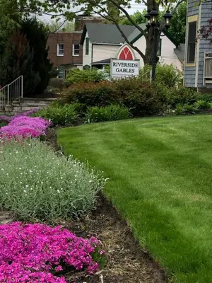 a yard with pink flowers in front of a house at Riverside Gables Bed and Breakfast in Berea