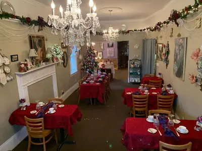 a dining room with red tables and a christmas tree at Emerald Necklace Inn Bed and Breakfast in Lakewood