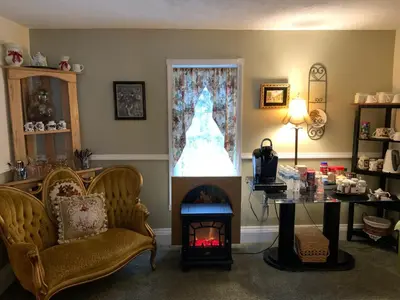a living room with a table and a fireplace at Emerald Necklace Inn Bed and Breakfast in Lakewood