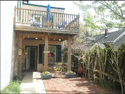 a house with a balcony on top of it at Emerald Necklace Inn Bed and Breakfast in Lakewood