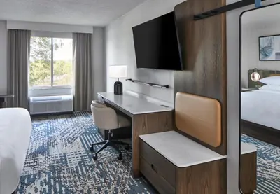 a hotel room with a desk and a bed at Delta Hotels by Marriott Toledo in Toledo