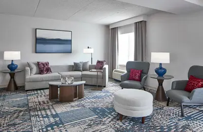 a living room with a couch and chairs and a table at Delta Hotels by Marriott Toledo in Toledo