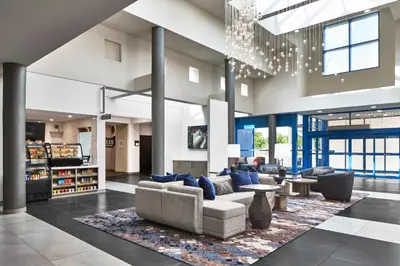 a lobby with couches and tables and a chandelier at Delta Hotels by Marriott Toledo in Toledo