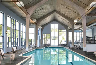 an indoor pool with tables and chairs and windows at Delta Hotels by Marriott Toledo in Toledo