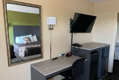 a room with a desk and a mirror and a bed at Travelodge by Wyndham Mansfield in Mansfield