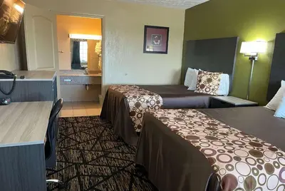a hotel room with two beds and a bathroom at Travelodge by Wyndham Mansfield in Mansfield