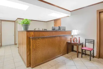 a reception desk in a hospital room with a potted plant at Travelodge by Wyndham Mansfield in Mansfield