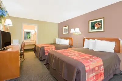 a hotel room with two beds and a flat screen tv at Travelodge by Wyndham Mansfield in Mansfield