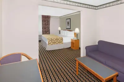 a hotel room with a bed and a couch at Baymont by Wyndham Fort Wayne in Fort Wayne
