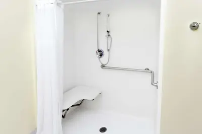 a shower with a white shower curtain in a bathroom at Baymont by Wyndham Fort Wayne in Fort Wayne