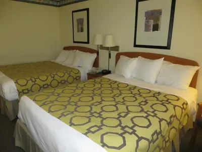 a hotel room with two beds and two lamps at Baymont by Wyndham Fort Wayne in Fort Wayne