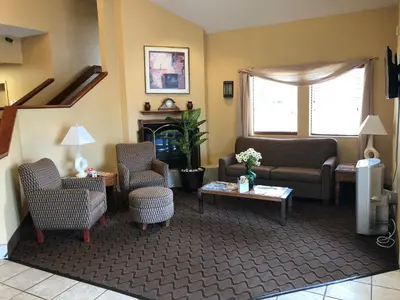 a living room with a couch and chairs and a table at Baymont by Wyndham Fort Wayne in Fort Wayne