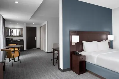 a hotel room with a bed and a desk and a table at Courtyard Cleveland University Circle in Cleveland
