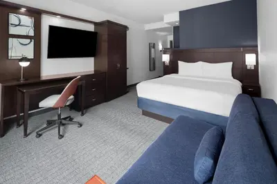 a hotel room with a bed and a desk and a computer at Courtyard Cleveland University Circle in Cleveland