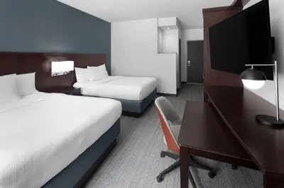 a hotel room with two beds and a desk at Courtyard Cleveland University Circle in Cleveland