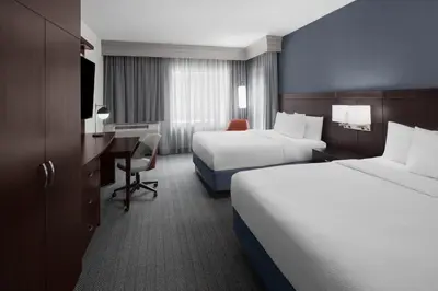 a hotel room with two beds and a desk at Courtyard Cleveland University Circle in Cleveland