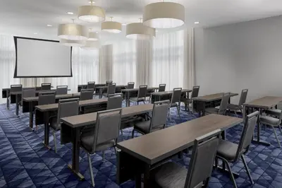 a conference room with tables and chairs and a projection screen at Courtyard Cleveland University Circle in Cleveland