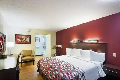 a hotel room with a large bed and a chair at Red Roof Inn Dayton - Fairborn/Nutter Center in Fairborn