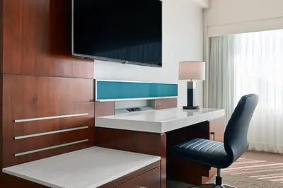 a hotel room with a desk and a television on a wall at Delta Hotels by Marriott Ashland Downtown in Ashland