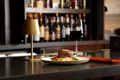 a plate of food on a counter with a glass of wine at Delta Hotels by Marriott Ashland Downtown in Ashland