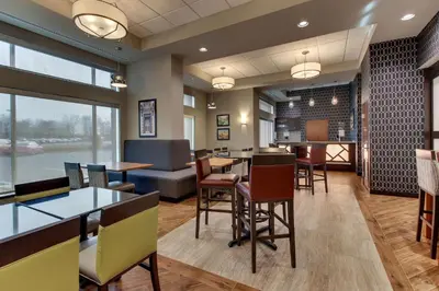 a restaurant with tables and chairs and a bar at Drury Inn & Suites Cleveland Beachwood in Beachwood