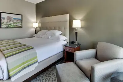 a hotel room with a bed and a chair at Drury Inn & Suites Cleveland Beachwood in Beachwood