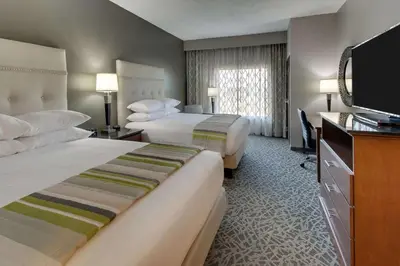 a hotel room with two beds and a flat screen tv at Drury Inn & Suites Cleveland Beachwood in Beachwood