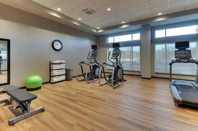a gym with exercise bikes and a clock in a room at Drury Inn & Suites Cleveland Beachwood in Beachwood