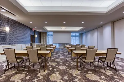 a conference room with tables and chairs and a projection screen at Drury Inn & Suites Cleveland Beachwood in Beachwood