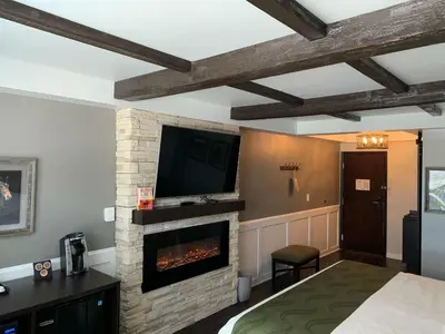 a bedroom with a fireplace and a tv on a wall at Cedar Stables Inn & Suites in Sandusky