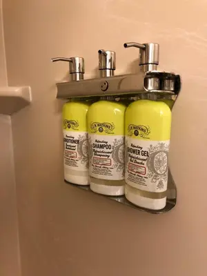 a rack with four bottles of paint on a wall at Cedar Stables Inn & Suites in Sandusky